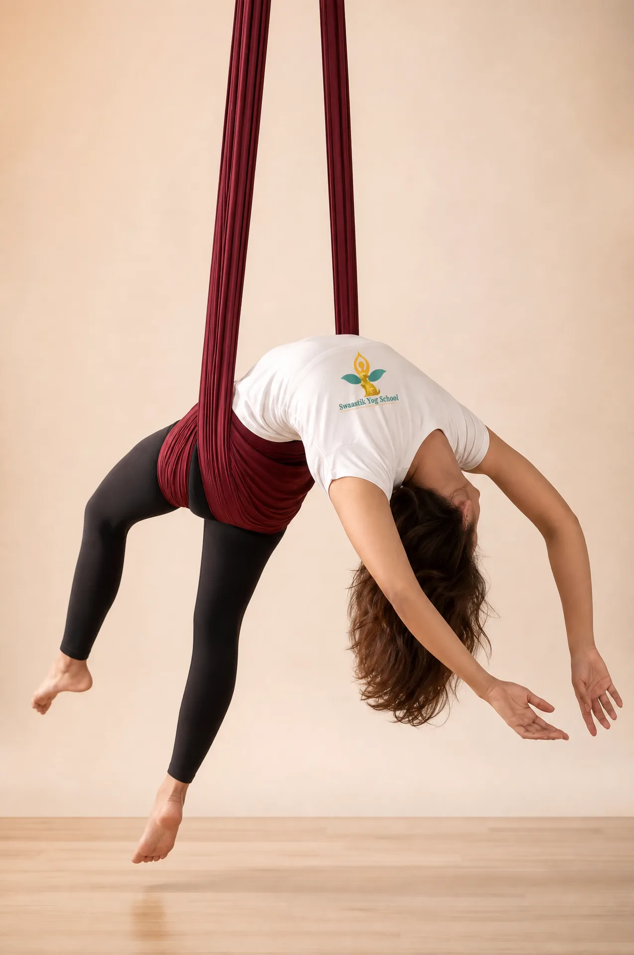 A student supported in a soft aerial hammock during a teacher training session in Tapovan, Rishikesh